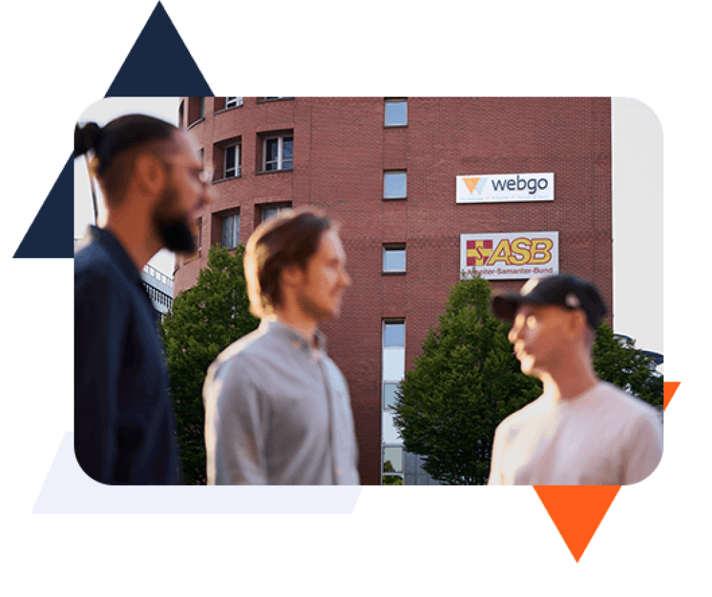 Drei Mitarbeitende von webgo auf dem Foto. Im Hintergrund das Gebäude der webgo GmbH am Heidenkampsweg 81 in 20097 Hamburg. Das Bild wird eingerahmt von blauen, orangefarbenen und weißen grafischen Elementen im webgo Stil.