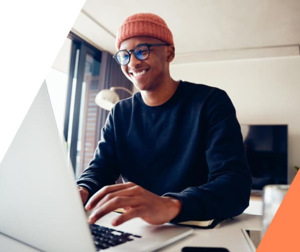 Mann arbeitet zufrieden auf seinem Laptop im Wohnzimmer – zeigt benutzerfreundliches und zuverlässiges CMS-Hosting für produktives Arbeiten von überall.