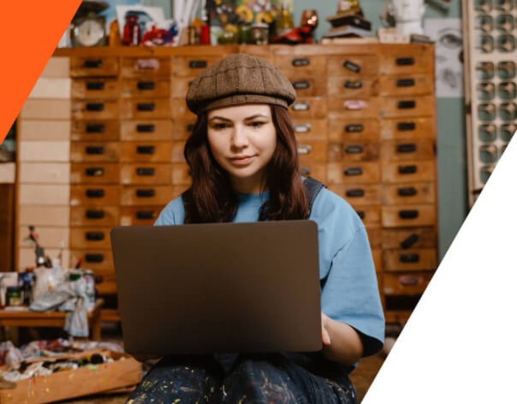 Frau in ihrem Atelier am Laptop – zeigt flexibles und zuverlässiges CMS-Hosting für kreative Berufe.
